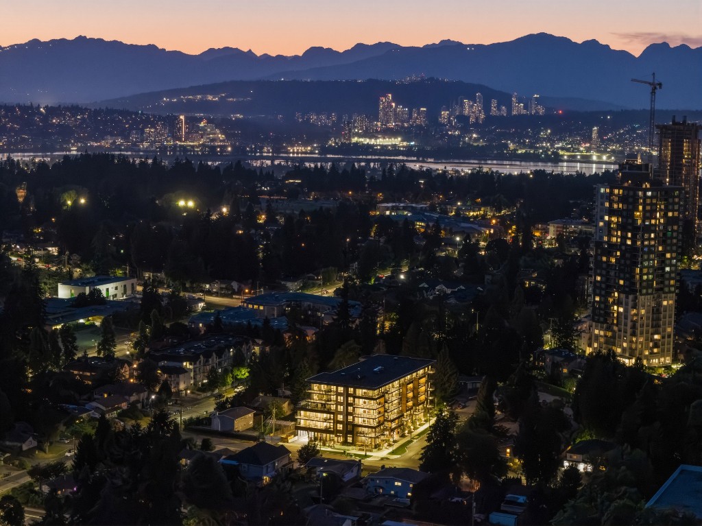 Aerial view of City Corners at dusk in Surrey City Centre, with downtown Vancouver in the distance