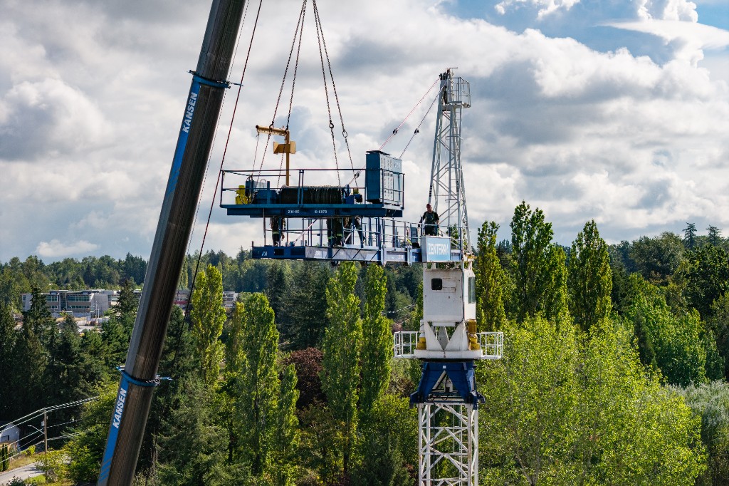 Mobile crane lifting the jib into place beside the tower crane at Clayton Crest in West Clayton, Surrey