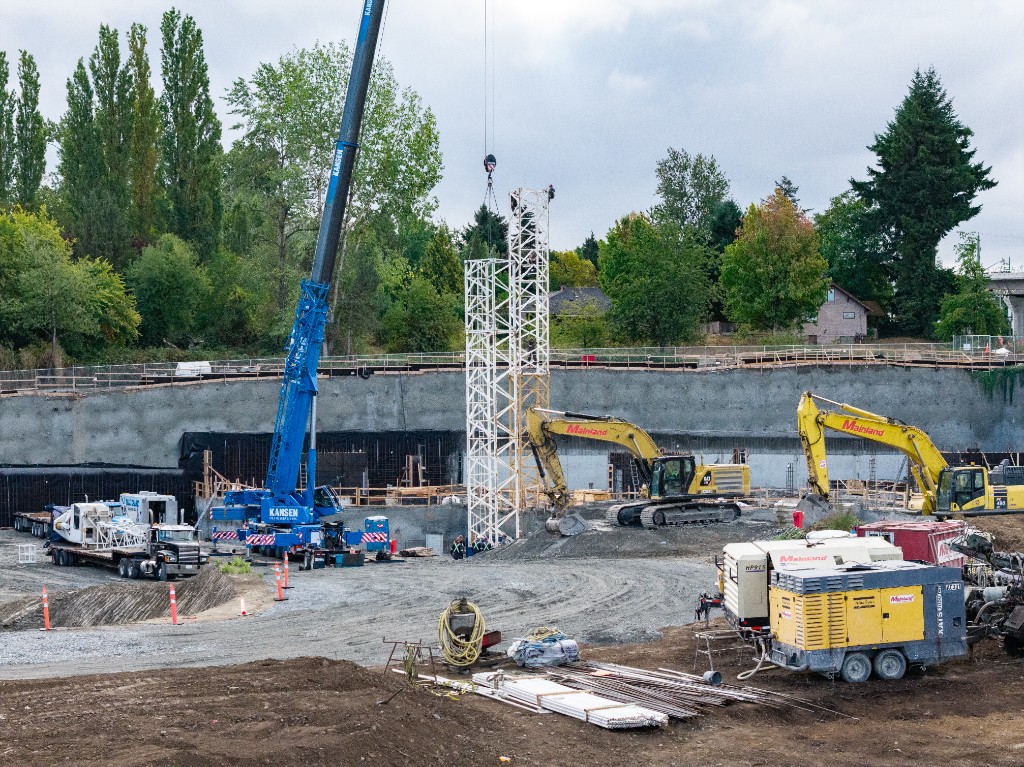 Mobile crane lifting the first tower sections on the Clayton Crest construction site in West Clayton, Surrey
